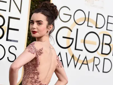 Aktris Lily Collins menghadiri ajang Golden Globe Awards yang digelar di Hotel Beverly Hilton, California, Minggu (8/1). Lily Collins tampil menawan bak princess dengan gaun haute couture cantik berwarna salem. (Jordan Strauss/Invision/AP)