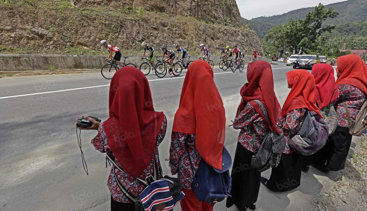 Anak-anak Sawahlunto menggunakan Karuduang menyaksikan Tourde Singkarak 2016 sebelum finish di Kota Sawahlunto, Sumatera Barat, Kamis (11/8/2016). (Bola.com/Nicklas Hanoatubun)