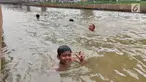 Anak-anak berenang di Sungai Kalimalang, Jakarta Timur, Jumat (5/7/2019). Tingginya suhu udara Ibu Kota akibat musim kemarau menyebabkan anak-anak tersebut berenang di Sungai Kalimalang meski dengan kondisi seadanya. (Liputan6.com/Immanuel Antonius)