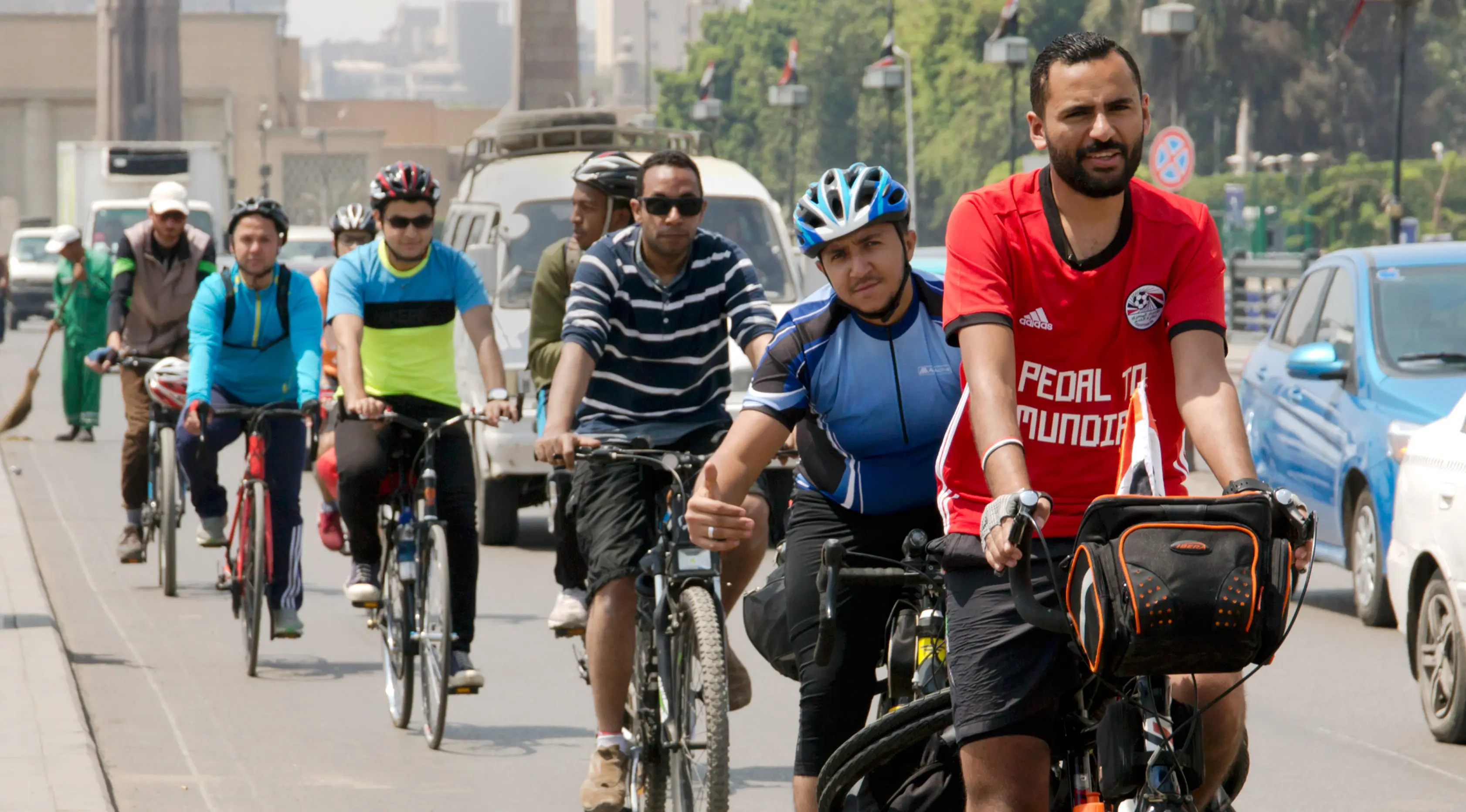 Pria asal Mesir, Mohammed Nufal (24) diikuti pendukungnya mengendarai sepedanya menuju Rusia di jembatan Qasr El-Nile, Kairo, Sabtu (7/4). Di sepedanya, Nufal sudah memuat suku cadang sepeda, baterai ponsel tambahan, dan peralatan berkemah. (AP/Amr Nabil)