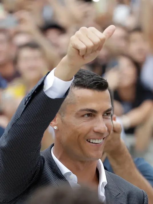 Cristiano Ronaldo menyapa suporter Juventus saat tiba di pusat layanan kesehatan Juventus (J-Medical), Turin, Italia, (16/7). Ronaldo akan mengenakan nomor punggung 7, seperti yang dikenakannya di Real Madrid. (AP Photo/Luca Bruno)