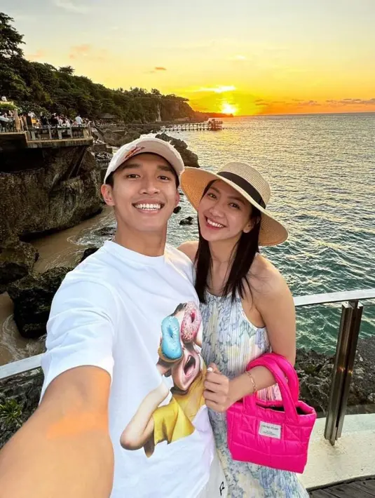 Sedangkan Shanju mengenakan sleeveless dress warna putih penuh motif yang dipadukan topi jerami dan mini handbag pink.