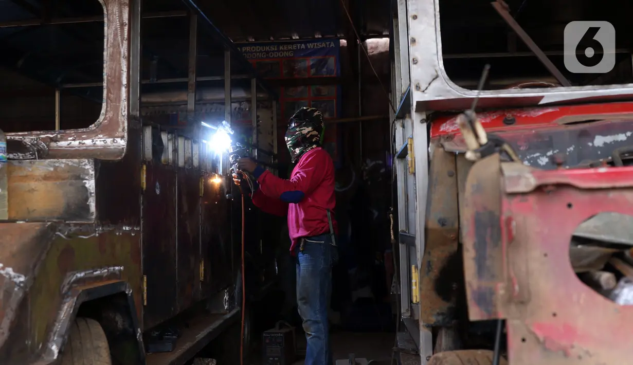 Pekerja menyelesaikan pembuatan odong-odong di Tangerang Selatan, Banten, Rabu (23/2/2022). Odong-odong yang dibuat dalam waktu sekitar satu bulan tersebut dijual dengan harga Rp 65 juta sampai Rp 100 juta, tergantung dari bahan pembuatan. (Liputan6.com/Angga Yuniar)