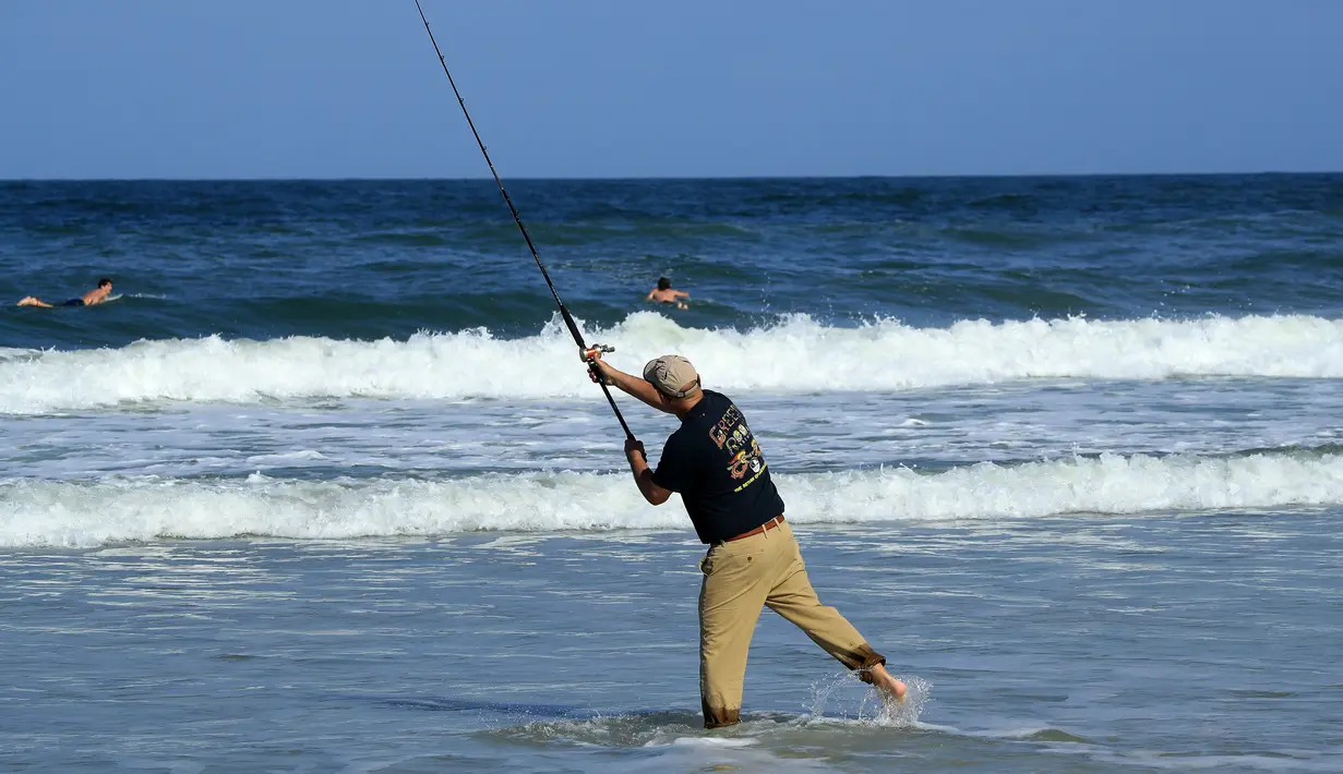 Seorang pria memancing di Jacksonville Beach, Florida (17/4/2020). Pantai tersebut dibuka kembali pada Jumat sore, 17 April 2020, waktu setempat. Hal ini dilakukan di tengah merebaknya pandemi corona Covid-19. (Sam Greenwood / Getty Images / AFP)