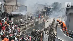 Petugas dibantu warga berusaha menjinakkan api yang melahap permukiman di Jalan Kebon Jeruk 13, Taman Sari, Jakarta Barat, Minggu (6/10/2019). Kebakaran diduga akibat anak bermain korek api. (merdeka.com/Iqbal Nugroho)