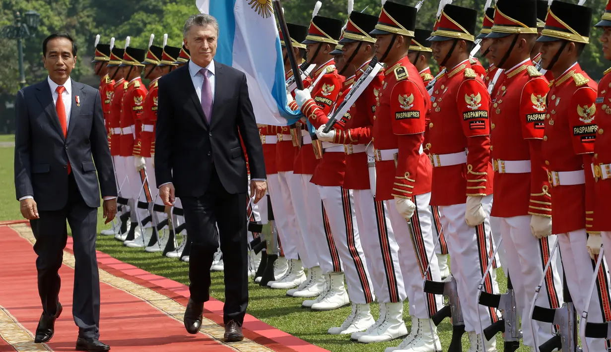 Presiden Joko Widodo berjalan bersama Presiden Argentina Mauricio Macri dalam upacara penyambutan kenegaraan di Istana Bogor, Rabu (26/6/2019). Jokowi dan Presiden Macri dijadwalkan melangsungkan pertemuan empat mata, pertemuan bilateral serta melakukan pernyataan pers bersama. (AP/Achmad Ibrahim)