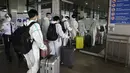 Penumpang asing yang mengenakan pakaian pelindung berbaris untuk penerbangan mereka ke China di Bandara Internasional Manila, Filipina, Senin (18/1/2021). Infeksi virus corona COVID-19 di Filipina telah melonjak melewati 500 ribu kasus.  (AP Photo/Aaron Favila)