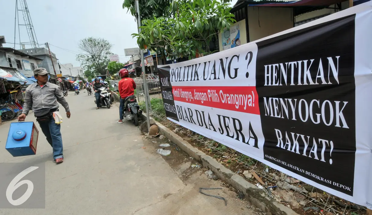Jelang Pemilihan suara, sebuah spanduk bertuliskan 'Hentikan Politik Uang' terpampang di bahu jalan pasar Musi Depok yang tidak jauh dari kelurahan Abadijaya Depok, Selasa (8/12). (Liputan6.com/Yoppy Renato)