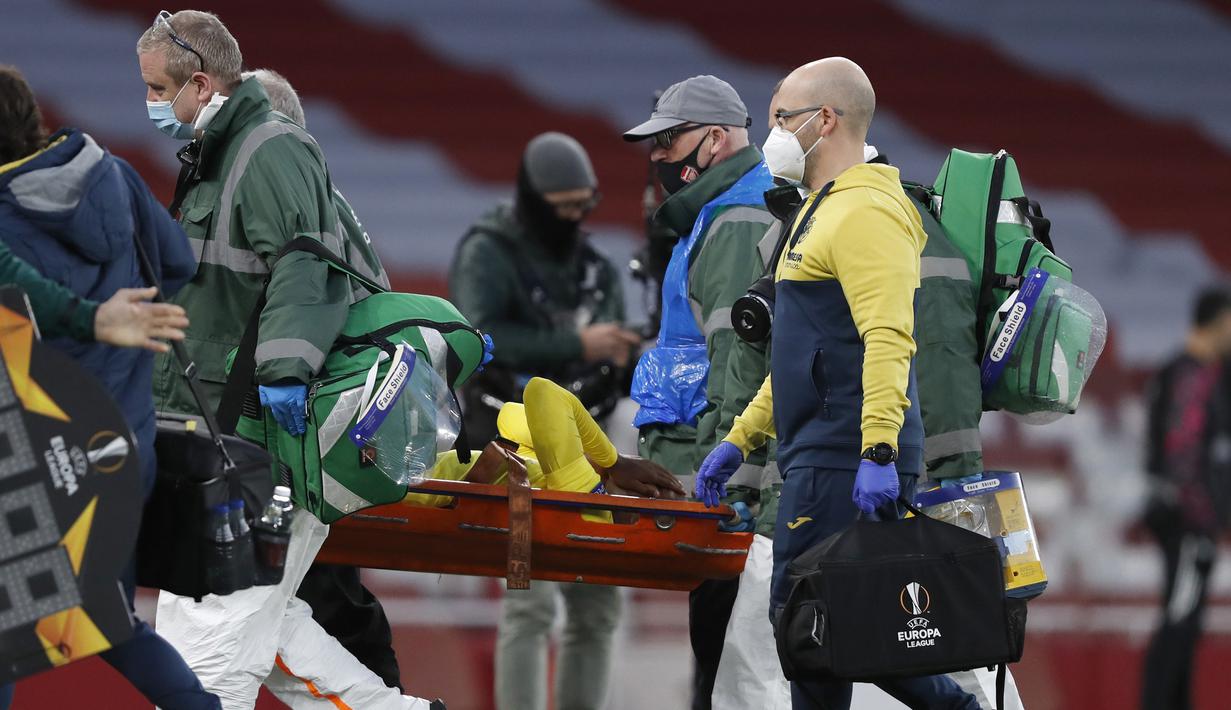 Gelandang Villarreal, Samuel Chukwueze ditandu keluar lapangan usai mengalami cedera saat melawan Arsenal dalam laga leg kedua semifinal Liga Europa 2020/2021 di Emirates Stadium, London, Kamis (6/5/2021). Villarreal bermain imbang 0-0 dengan Arsenal. (AP/Alastair Grant)