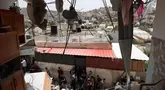 Warga Palestina memeriksa kerusakan di sekitar bangunan yang hancur setelah pasukan Israel mengepungnya di Tammun, Tepi Barat yang diduduki pada tanggal 15 Mei 2025. (Zain JAAFAR/AFP)