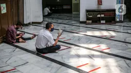 Umat Muslim membaca Al-Quran di Masjid Cut Meutia, Jakarta, Kamis (30/7/2020). Masjid Cut Meutia akan menggelar Salat Idul Adha esok hari dengan menerapkan protokol kesehatan pencegahan Covid-19. (Liputan6.com/Faizal Fanani)