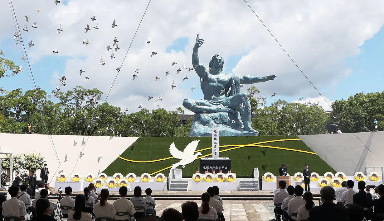 Merpati terbang di atas Patung Perdamaian selama upacara di Taman Perdamaian Nagasaki di Nagasaki, Jepang selatan, Senin (9/8/2021). Kota Nagasaki di Jepang pada hari Senin menandai peringatan ke-76 bom atom AS. (Kyodo News via AP)