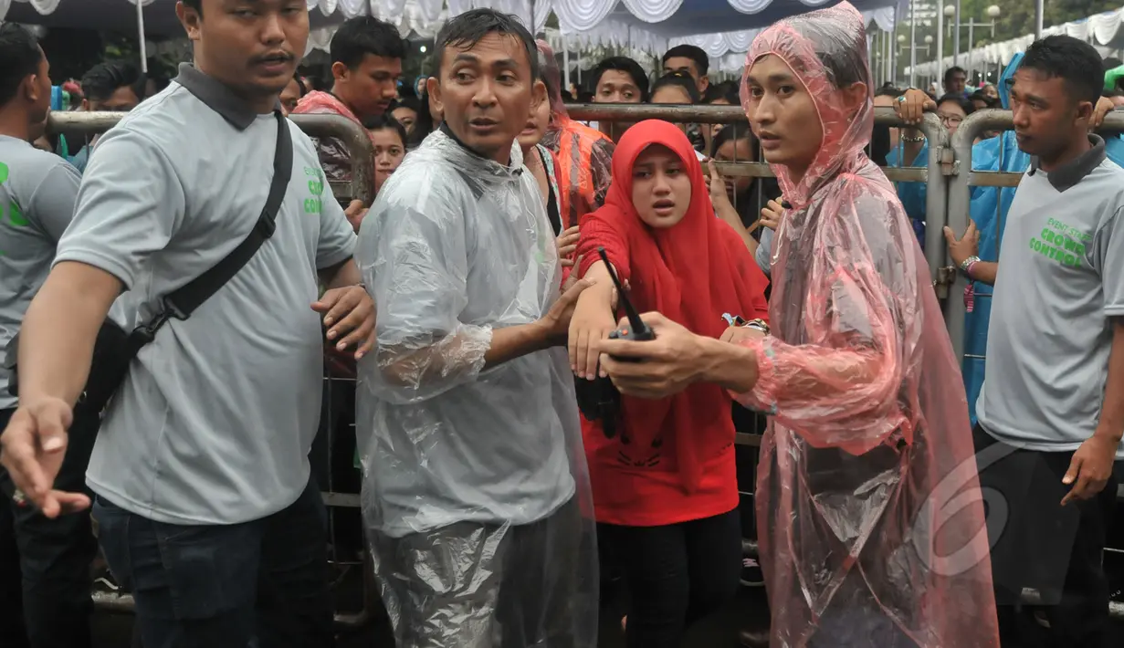 Sejumlah fans diamankan petugas karena limbung saat saat mengantre untuk menonton konser One Direction, Senayan, Jakarta, Rabu (25/3/2015). Puluhan ribu orang rela mengantre untuk melihat konser One Direction. (Liputan6.com/Johan Tallo)