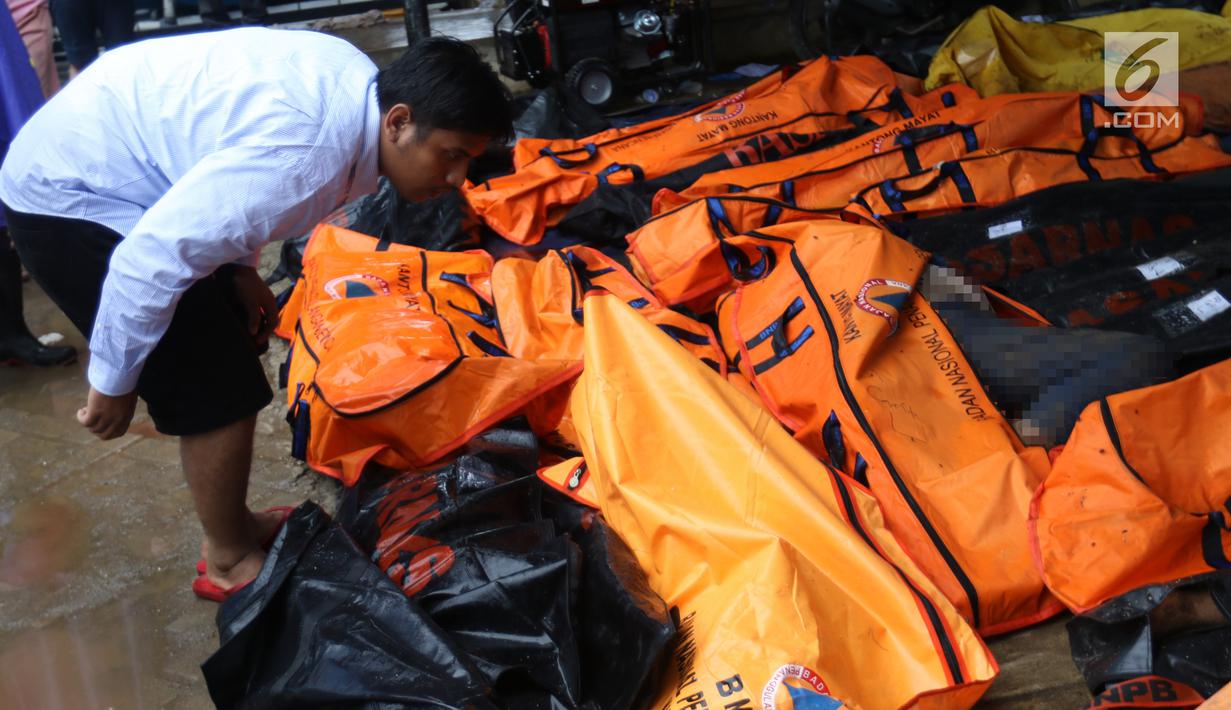 Warga melihat jenazah korban gelombang Tsunami Anyer di Puskesmas Carita, Banten, Minggu (23/12). Tim SAR masih melakukan pencarian jenazah yang sebagian besar berasal dari Pantai Carita. (Liputan6.com/Angga Yuniar)