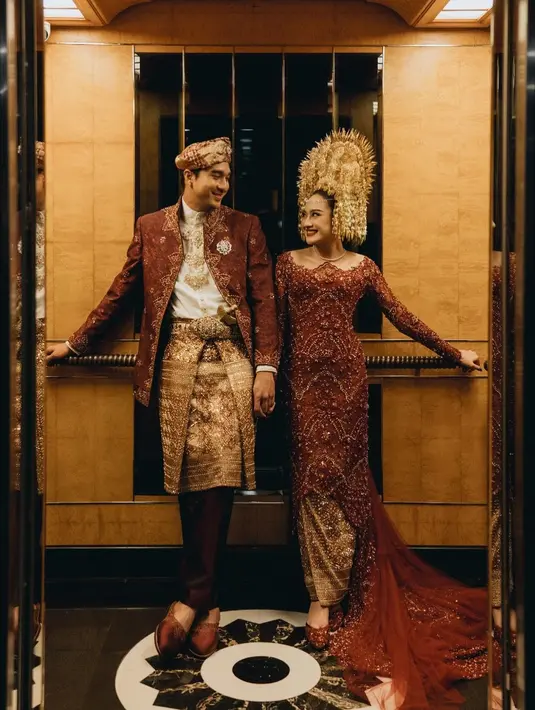 Kali ini, pilihannya jatuh kepada kebaya Minang warna merah dengan taburan payet yang memberi impresi mewah. Ia menyelesaikan penampilannya dengan suntiang emas. [@morden.co]
