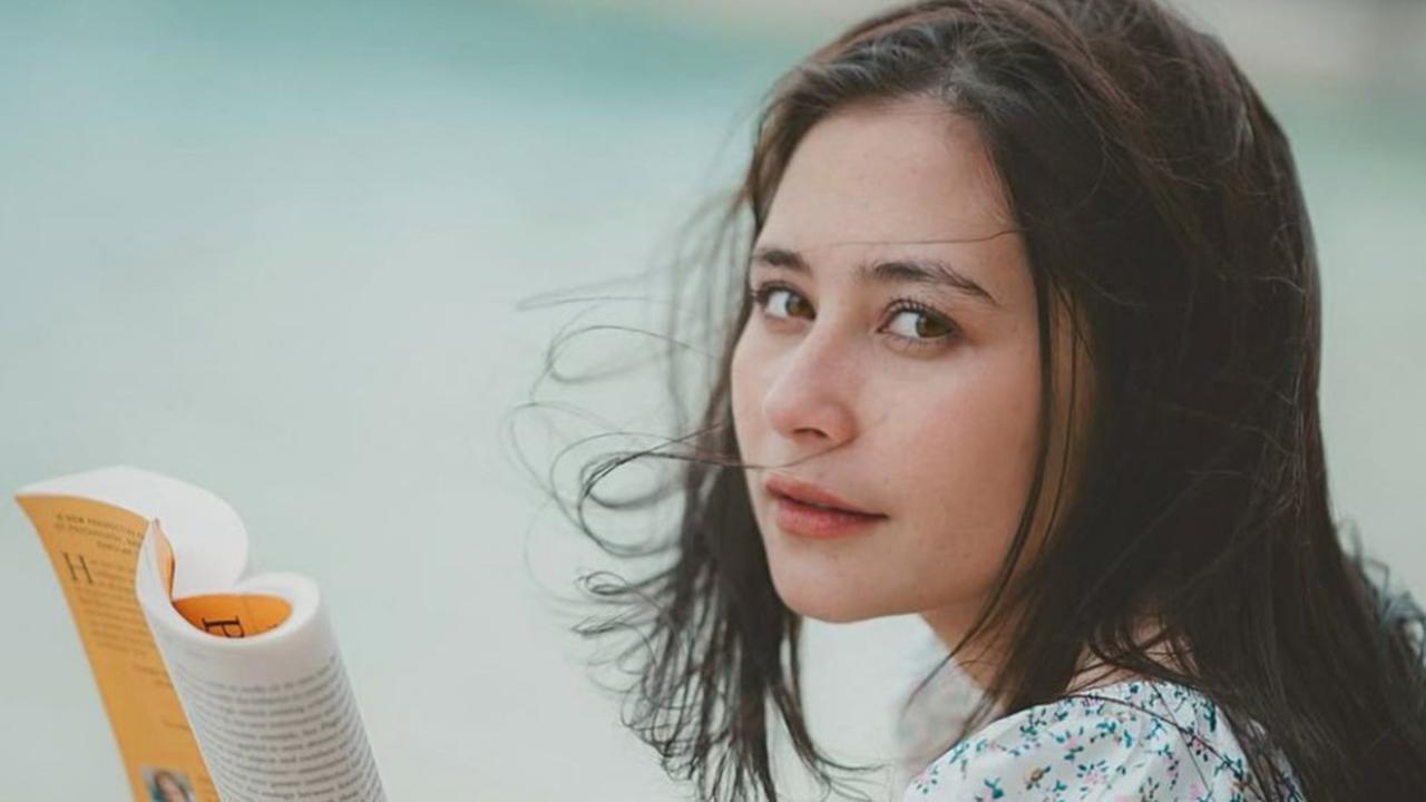 Rambut Berantakan dan Pesona Cantik Natural Prilly Latuconsina Habiskan Waktu di Pinggir Pantai Sambil Baca Buku