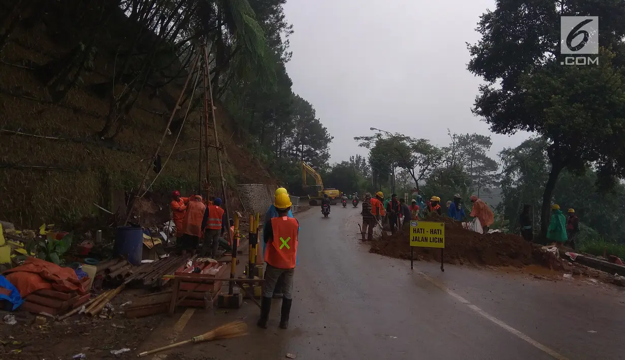 Sejumlah petugas menggunakan alat berat untuk memperbaiki jalur yang tertimpa longsor di kawasan Puncak, Bogor, Jawa Barat, Rabu (14/2). Pasca penutupan jalur akibat longsor membuat kawasan Puncak berubah seperti kota mati. (Liputan6.com/Achmad Sudarno)