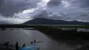 Nelayan India meletakkan jala ikan mereka saat senja di surutnya air banjir di sawah di pinggiran Gauhati, India, Senin (14/9/2020). (AP Photo / Anupam Nath)