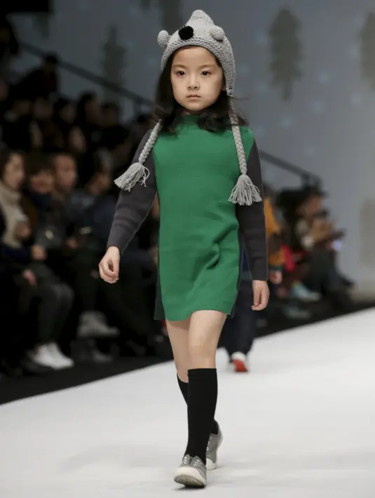 Seorang anak saat membawakan busana koleksi M.latin di Cina Fashion Week S/S 2016 di Beijing, Cina, Rabu (28/10/2015) . Acara ini berlangsung dari 25-31 Oktober 2015. (REUTERS/Jason Lee)