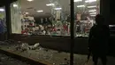 Polisi AL Meksiko mengamankan sebuah toko setelah aksi penjarahan di negara bagian Veracruz, Rabu (4/1). Penjarahan terjadi di sejumlah toko di Meksiko, seiring berlangsungnya unjuk rasa memprotes kenaikan harga bahan bakar minyak. (Ilse HUESCA/AFP)