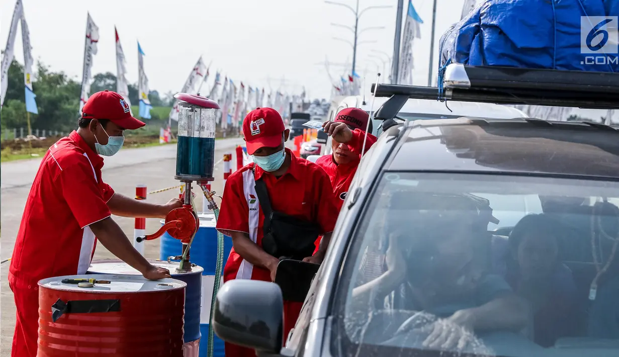 Petugas mengisi BBM kendaraan di kios Pertamina tol fungsional Brebes Timur-Gringsing, Tegal, Jawa Tengah, Jumat (30/6). Ketersedian BBM dengan stok pertamax 740 ribu KL (22 hari) dan solar 1,887 juta KL (27 hari). (Liputan6.com/Faizal Fanani)