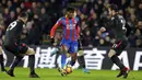 Gelandang Crystal Palace, Wilfried Zaha, berusaha melewati pemain Arsenal pada laga Premier League di Stadion Selhurst Park, Jumat (29/12/2017). Arsenal menang 3-2 atas Crystal Palace. (AP/Alastair Grant)