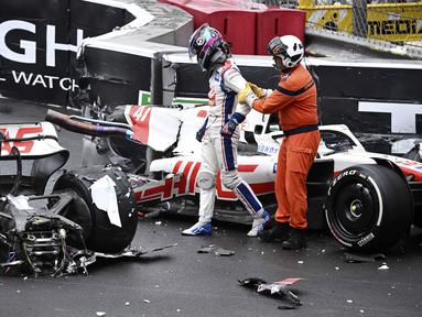 Pembalap Tim Haas, Mick Schumacher dibantu oleh marshall keluar dari mobilnya usai mengalami kecelakaan saat Formula 1 GP Monako yang berlangsung di Circuit de Monaco, Minggu, 29 Mei 2022. (AP/Pool/Christian Bruna)