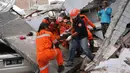 Tim penyelamat membawa korban selamat dari sebuah bangunan restoran yang rusak akibat gempa dan tsunami yang menghantam Palu, Sulawesi Tengah, Minggu (30/9). (AP Photo/Tatan Syuflana, File)