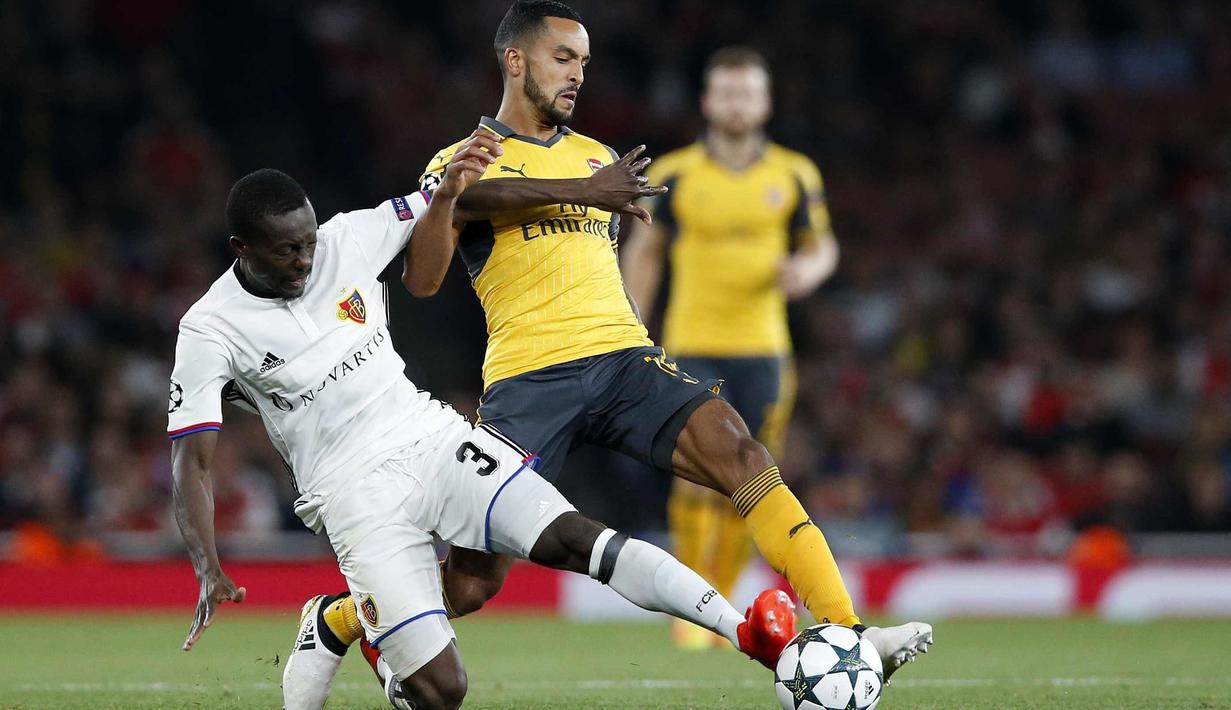 Pemain Basel, Adama Traore (kiri) berebut bola dengan pemain Arsenal, Theo Walcott pada laga grup A Liga Champions di Emirates stadium, London, Kamis (29/9/2016)dini hari WIB. Arsenal menang 2-0. (AP/Alastair Grant)