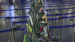 Pohon Natal yang dirakit dari barang-barang sitaan di Bandara Vilnius, Lithuania pada 12 Desember 2019. Bagian tubuh pohon Natal dibuat dengan menggunakan gunting yang dicat warna hijau agar terlihat seperti daun. . (Photo by Petras Malukas / AFP)