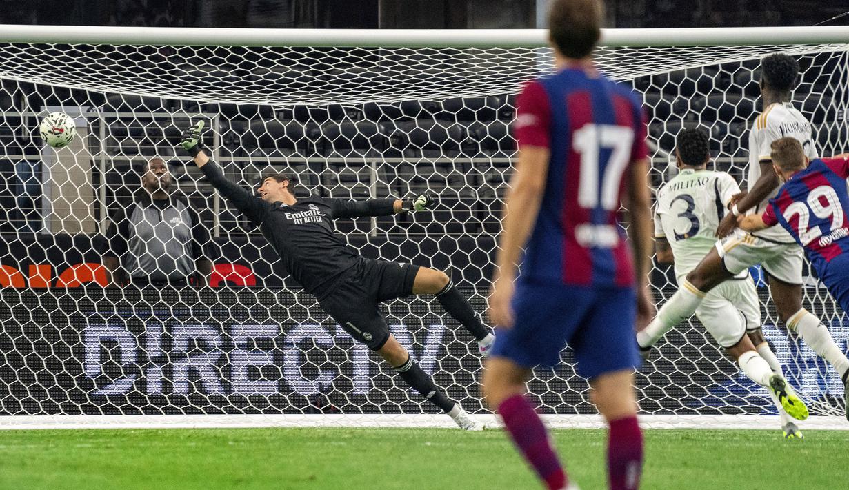 Kiper Real Madrid, Thibaut Courtois kemasukkan gol kedua oleh striker Barcelona, Fermin Lopez pada laga pramusim Soccer Champions Tour 2023 di AT&T Stadium, Arlington, Texas, Minggu (30/7/2023) dini hari WIB. (AP Photo/Jeffrey McWhorter)