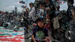 Seorang anak perempuan bermain gelembung selama pertunjukan seni Bubble Up yang dibuat oleh seniman asal Jepang, Shinji Ohmaki, di Hong Kong, 2 Agustus 2017. (AP Photo/Kin Cheung)