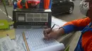 Petugas mengisi form uji emisi gas buang kendaraan di Kalibata, Jakarta, Rabu (24/7). Uji emisi kendaraan di lakukan untuk kadar kualitas udara perkotaan, seiring meningkatnya volume kendaraan bermotor di kota-kota besar. (Merdeka.com/Imam Buhori)