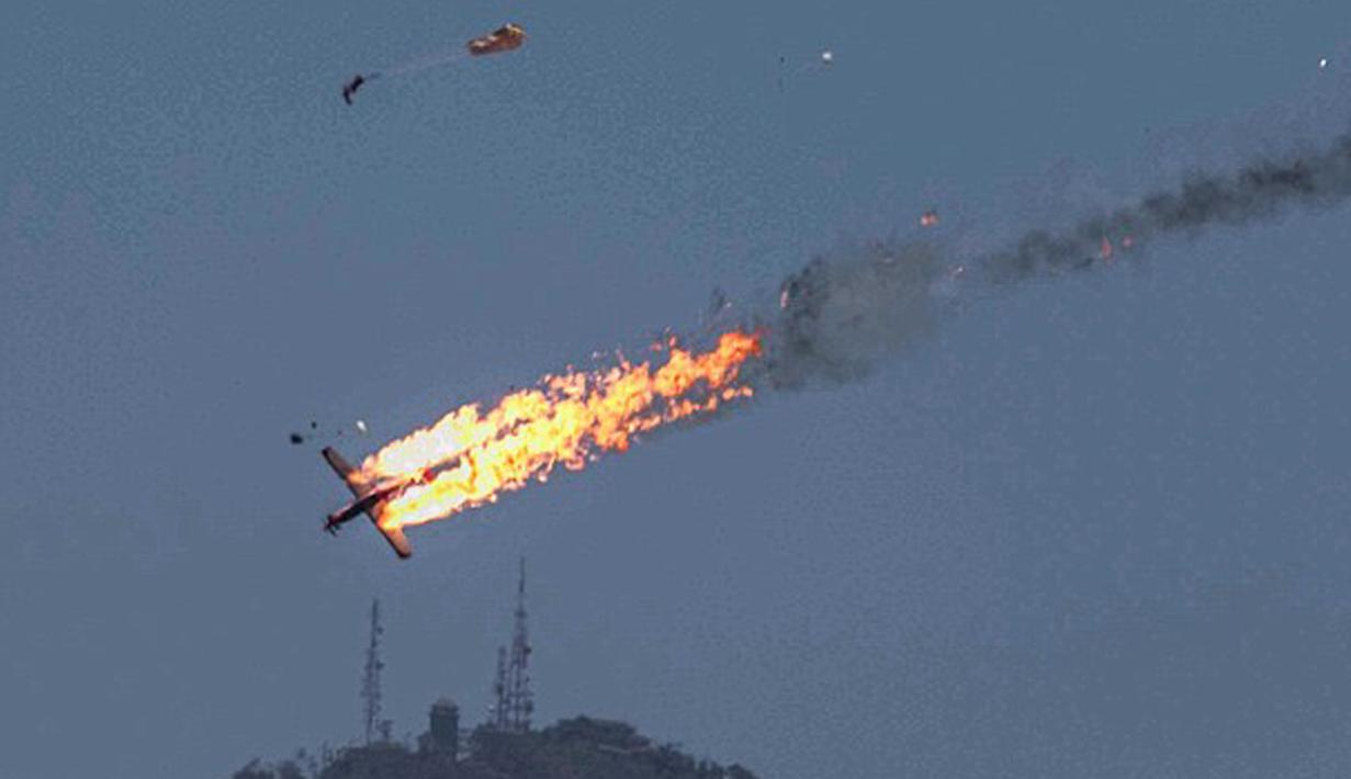 Dua pesawat Wong Bee KT-1B milik TNI AU bertabrakan hingga membuat ledakan dan terbakar jelang pameran Dirgantara Langkawi, Malaysia, Minggu (14/3/2015). Para pilot terlihat menyelamatkan diri dengan dengan parasut. (Dailymail)