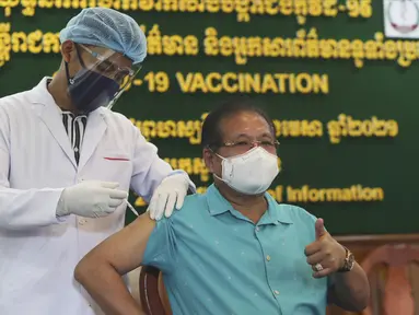 Direktur Kementerian Informasi Kamboja Jenderal Ly Vannhong (kanan) menerima suntikan vaksin COVID-19 Sinovac di Kementerian Informasi selama kampanye inokulasi melawan virus corona di Phnom Penh, Kamboja, Kamis (1/4/2021).  (AP Photo/Heng Sinith)