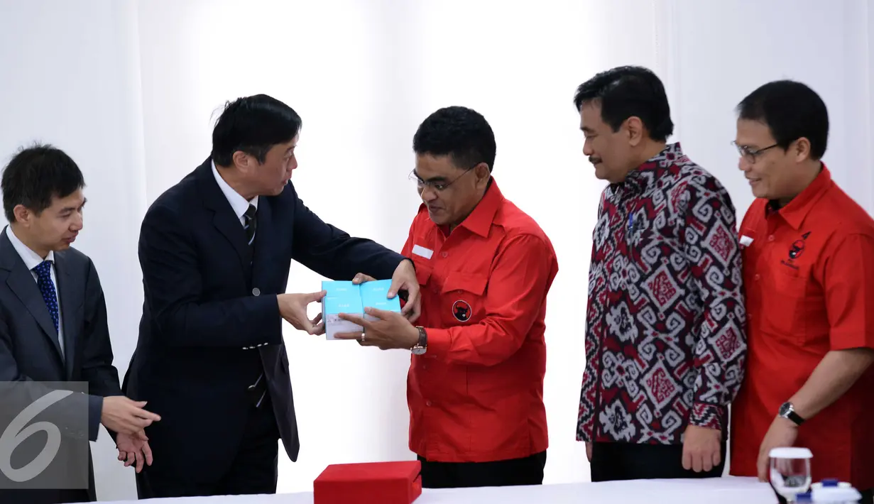 Ketua DPP PDIP Andreas Hugo Pareira menerima cenderamata dari Delegasi Shenzhen yang dipimpin Komite Tetap Partai Kota Shenzhen Tian FU (kedua kiri) usai melakukan pertemuan di Kantor DPP PDIP, Jakarta, Selasa (24/11). (Liputan6.com/Helmi Afandi)