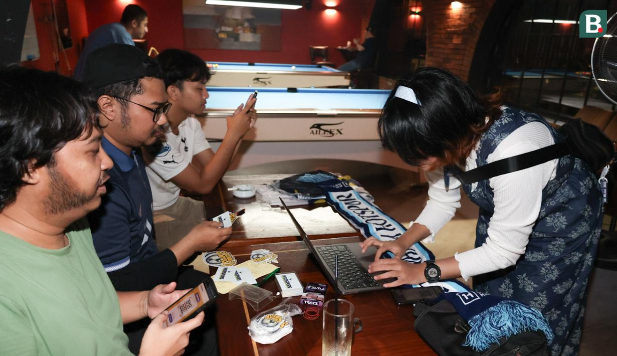Seorang pengunjung tengah melakukan registrasi nonton bareng Roaring Night Liga Inggris 2023/2024 antara Tottenham Hotspur kontra Arsenal di Treehaus Kemang, Minggu (28/4/2024) malam WIB yang digelar komunitas penggemar Tottenham Hotspur, IndoSpurs Jakarta. (Bola.com/Abdul Aziz)