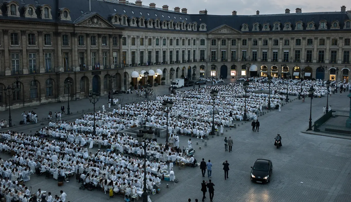 Ratusan orang turut ambil bagian dalam 'Diner en blanc' atau 'Makan Malam Putih' digelar di Place Vendome, Paris, Rabu (8/6). Dalam tradisi yang sudah digelar selama 25 tahun itu, peserta harus mengenakan aksesoris serba putih. (PHILIPPE LOPE/AFP)
