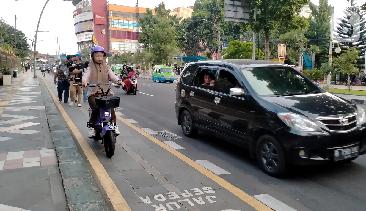 Warga mengendarai sepeda listrik saat berkeliling di jalur sepeda kawasan Kebun Raya Bogor, Kota Bogor, Jawa Barat, Minggu (25/9/2022). Pemerintah Kota (Pemkot) Bogor akan mulai membiasakan warganya untuk menggunakan transportasi dengan tenaga listrik. (Liputan6.com/Magang/Aida Nuralifa)