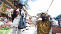 Relawan Protokol Kesehatan PON XX Kabupaten Jayapura memberikan masker dan edukasi kepada masyarakat di Pasar Baru Sentani, Jayapura terhadap pentingnya penerapan protokol kesehatan, Selasa (28/9/2021). (Dok BNPB)