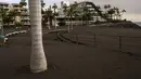 Abu gunung berapi Cumbre Vieja menutupi kawasan pejalan kaki desa Puerto Naos di pulau Canary La Palma, Spanyol, Rabu (27/10/2021). Penduduk di Pulau La Palma menghadapi kemungkinkan gempa yang lebih kuat yang bisa memperparah kerusakan oleh muntahan lava gunung tersebut. (AP Photo/Emilio Morenatti)