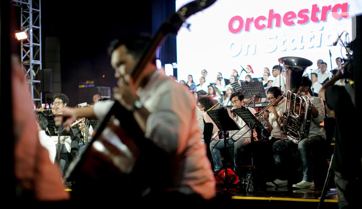 Komposer Addie MS tampil bersama kelompok musik simfoni Twilite Orchestra pada acara Orchestra On Station di Stasiun BNI City, Jakarta, Jumat (16/9/2022). Pertunjukan diselenggarakan dalam rangka rangkaian HUT PT Kereta Commuter Indonesia (KCI) ke -14. (Liputan6.com/Faizal Fanani)