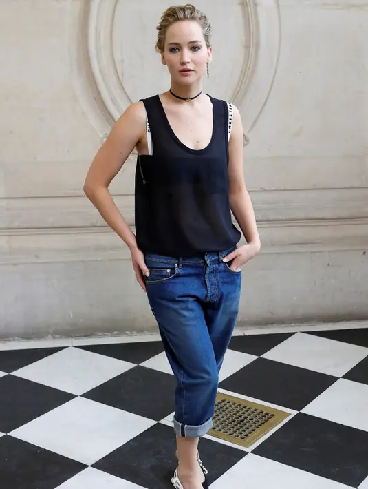 Jennifer Lawrence berpose jelang menghadiri peragaan busana koleksi Spring/Summer 2017 Christian Dior di Paris Fashion Week 2017, Prancis, (30/9). Memakai celana jeans dan busana transparan Jennifer Lawrence tampil cantik. (AFP Photo/Patrick Kovarik)