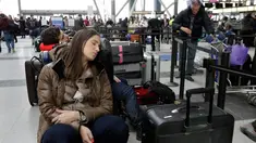 Penumpang maskapai Avianca menunggu penerbangan yang tertunda di Bandara Internasional John F Kennedy (JFK), New York, Senin (8/1). Banjir yang disebabkan kerusakan saluran air mengakibatkan kekacauan dan pembatalan sejumlah penerbangan. (AP/Richard Drew)