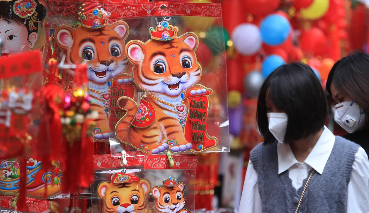 Orang-orang berbelanja di pasar "Tet" Tahun Baru Imlek tradisional di kawasan tua Hanoi, Vietnam, Jumat (28/1/2022). Vietnam merayakan Tahun Baru Imlek yang akan datang di tengah peringatan terhadap perjalanan dan pertemuan besar karena COVID -19. (AP Photo/Hau Dinh)