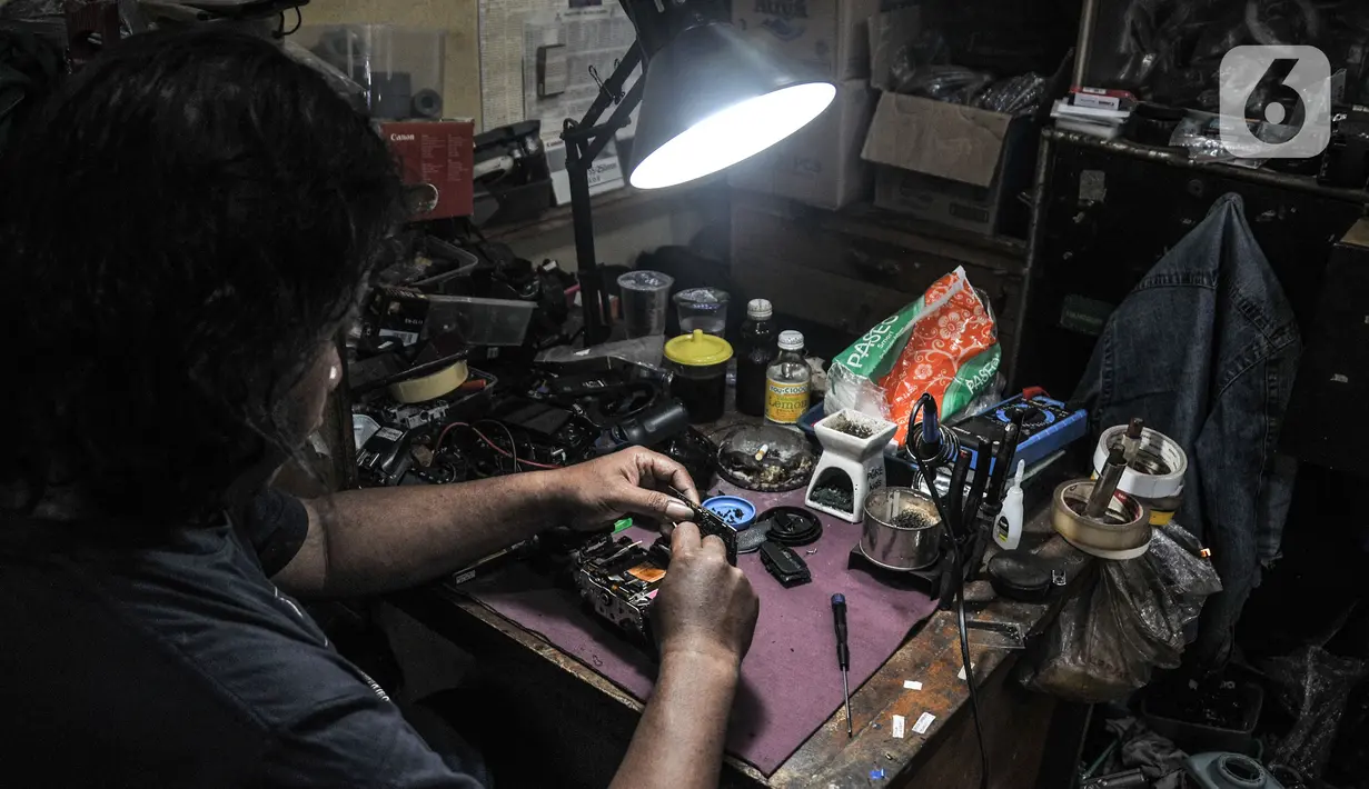 Pekerja menyelesaikan servis kamera di salah satu toko Metro Atom Plaza, Pasar Baru, Jakarta, Senin (15/11/2021). Akibat menurunnya omzet selama pandemi Covid-19, sejumlah toko kamera di Pasar Baru terpaksa gulung tikar. (merdeka.com/Iqbal S Nugroho)