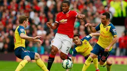 Gelandang Manchester United, Antonio Valencia (tengah) berusaha melewati dua pemain Arsenal saat Laga Liga Premier Inggris di Stadion Old Trafford, Minggu (17/5/2015). Manchester United bermain imbang 1-1 atas Arsenal. (Reuters/Jason Cairnduff)