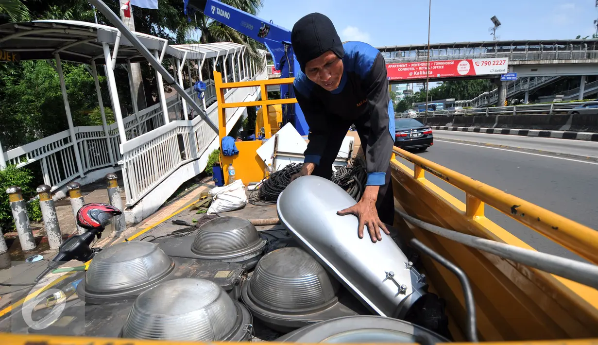 Pekerja merapihkan lampu PJU yang telah diganti dengan lampu hemat energi LED di Jakarta, Selasa (29/12). Pemrov DKI Jakarta mengganti lampu listrik Penerangan Jalan Umum (PJU) dari konvensional menjadi lampu hemat energi LED. (Liputan6.com/Yoppy Renato)