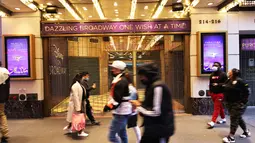 Orang-orang berjalan melewati Theater District di Manhattan, New York City, Kamis (6/5/2021). Gubernur Andrew Cuomo mengumumkan teater Broadway akan dibuka kembali dalam kapasitas penuh mulai 14 September, sejak ditutup Maret 2020 karena pandemi COVID-19. (MICHAEL M. SANTIAGO/GETTY IMAGES VIA AFP)Or