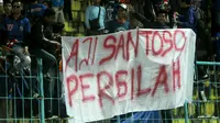 Aremania membentangkan spanduk soal Aji Santoso setelah Arema FC gagal mengalahkan Borne FC, Minggu (30/7/2017) di Stadion Kanjuruhan, Kabupaten Malang. (Bola.com/Iwan Setiawan)